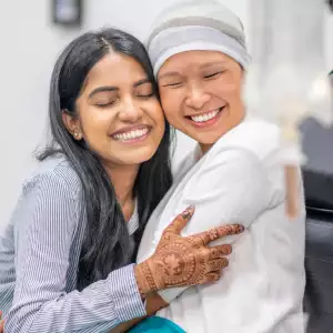 Woman hugging cancer patient