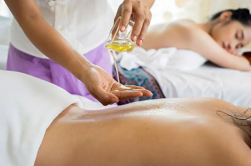 A serene spa scene featuring a woman receiving a relaxing back massage